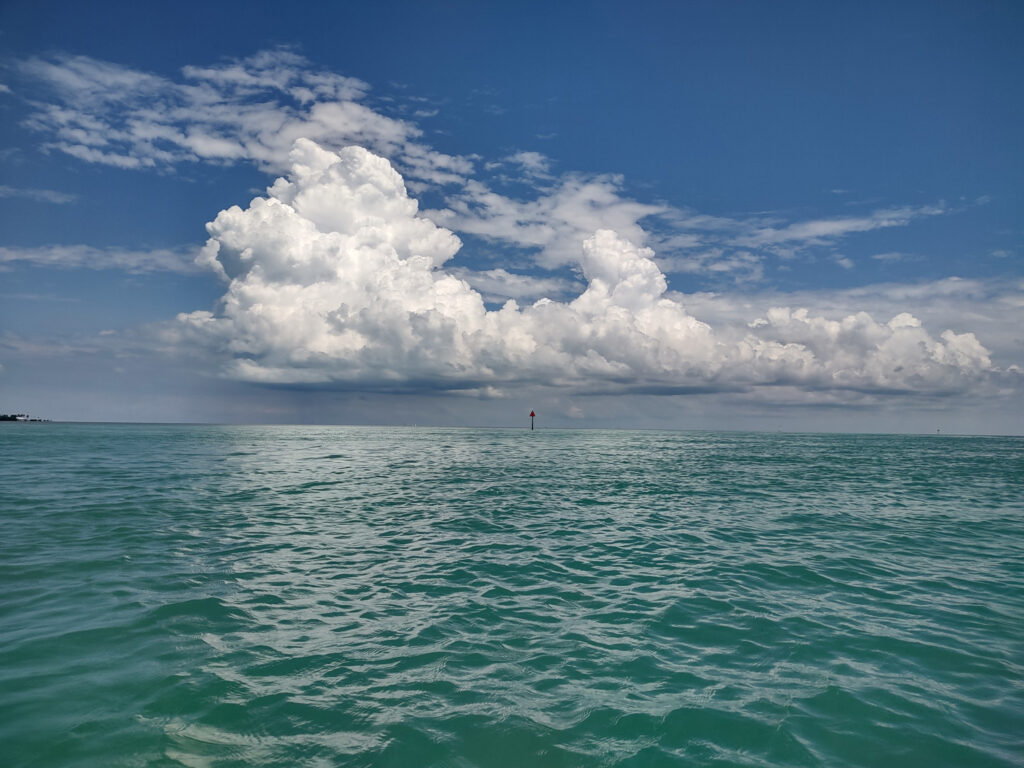 A lone sign juts above the turquoise waters of the Florida Keys shows the best time to visit the Florida Keys.