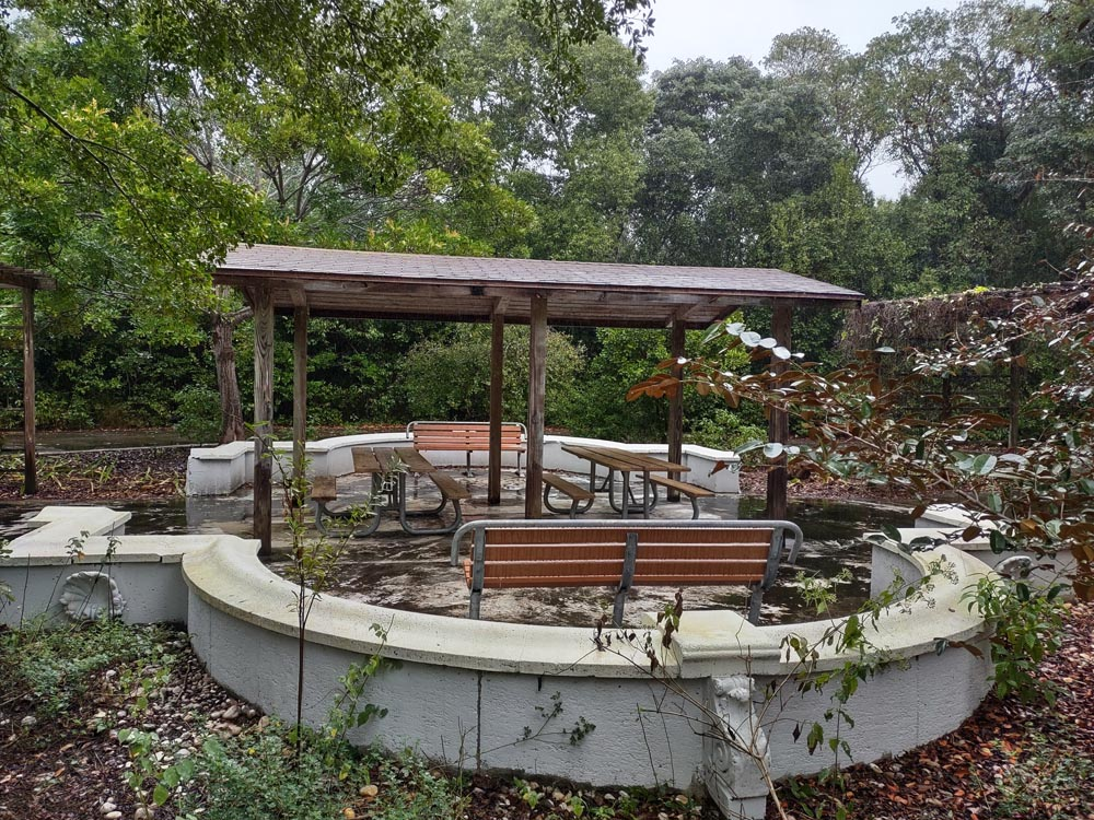 A covered pavilion with picnic tables, benches, and a knee-high circular wall at Dagny Johnson State Park.