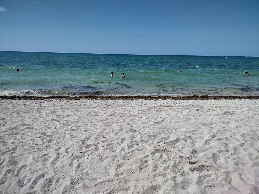 White sandy beach meets turquoise waters under a blue cloudless sky at Sombero Beach Marathon. One of the best beaches in the Florida Keys.